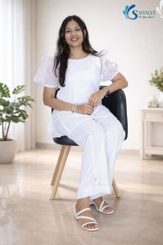 Model wearing Saivalya Fashion Alaya Pearl White Co-ord Set with sheer organza puff sleeves, Pearl neckline and matching straight-fit trousers in a bright indoor setting